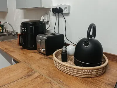 a counter top with a microwave and a tea kettle at Cozy one bed, just a short walk to the beach in Strand