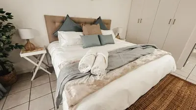 a bedroom with a large bed with towels on it at Cozy one bed, just a short walk to the beach in Strand