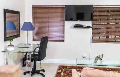 a living room with a glass table and a chair at Campbell's Corner in Cape Town