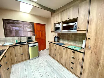 a kitchen with wooden cabinets and a green refrigerator at Modern Van Riebeeck Park Accomodation in Worcester