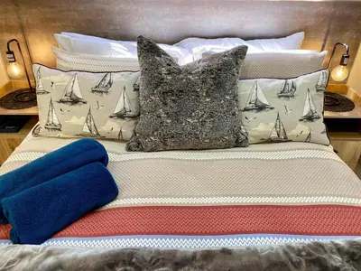 a bed with two pillows with sails on it at Modern Van Riebeeck Park Accomodation in Worcester