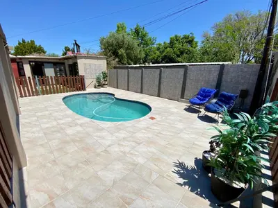 a patio with two chairs and a small swimming pool at Modern Van Riebeeck Park Accomodation in Worcester