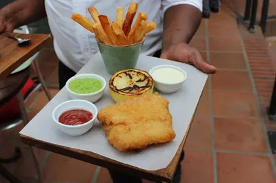 a tray of food with fish and french fries and sauce at The Stellenbosch Hotel in Stellenbosch