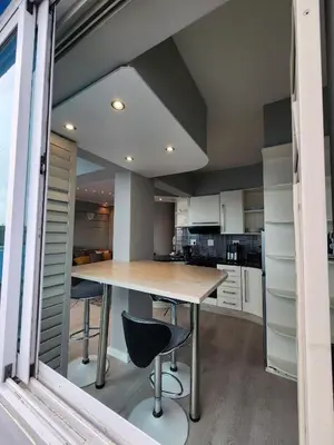 a large kitchen with a table and two chairs at Seaview Serenity Strand in Strand