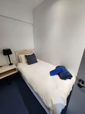 a bedroom with a white bed with blue pillows on it at Seaview Serenity Strand in Strand