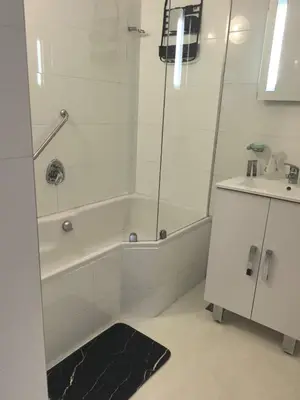 a bathroom with a shower and a tub and a sink at Seaview Serenity Strand in Strand