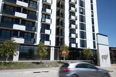 a car driving in front of a tall building at Riverlands Luxury Apartments by City Club in Cape Town