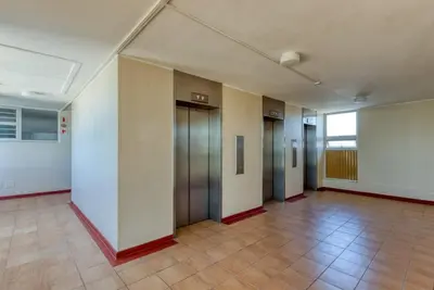 an empty hallway with doors and a tile floor at Ashley On Beach 1104 Prestige Style in Strand