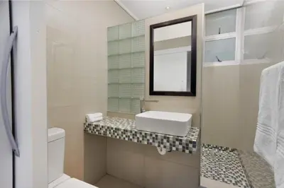 a white bathroom with a sink and a mirror at Ashley On Beach 1104 Prestige Style in Strand