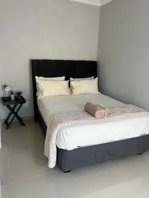 a bed with a black headboard in a bedroom at Nemesia guest house in Cape Town