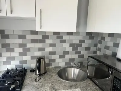a kitchen with a stainless steel sink and a stove at Nemesia guest house in Cape Town