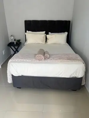 a bedroom with a bed with two towels on it at Nemesia guest house in Cape Town