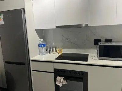 a kitchen with a microwave and a stove top oven at The black and white suite in Blackheath