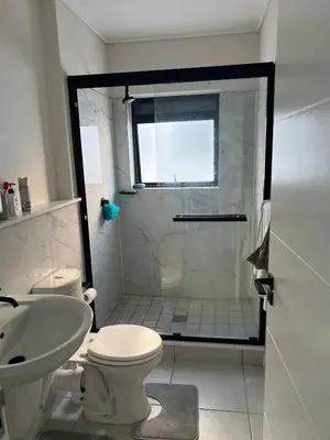 a bathroom with a shower and a toilet and a sink at The black and white suite in Blackheath