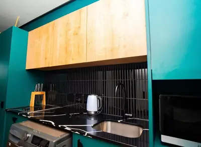 a kitchen with a sink and a microwave at Modern Studio Steps from Ratanga Park in Cape Town