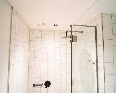 a bathroom with a shower with a glass door at Modern Studio Steps from Ratanga Park in Cape Town