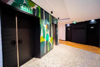 a corridor of a gym with doors and a wall with a sign at Modern Studio Steps from Ratanga Park in Cape Town