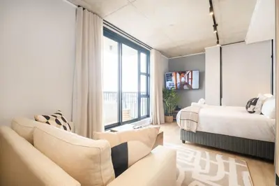 a bedroom with a bed and a large window at S500 Riverlands - Lux Studio Apartment in Cape Town