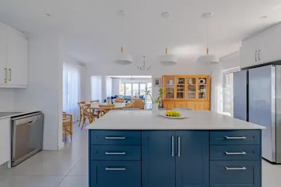 a kitchen with blue cabinets and a dining room at Serenity on 6th Luxury holiday home in Hermanus