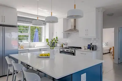 a kitchen with white cabinets and a white counter top at Serenity on 6th Luxury holiday home in Hermanus