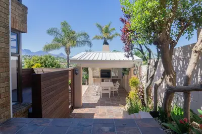 a patio with a gazebo with a table and chairs at Begonias Eden in Helderberg