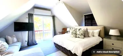 a bedroom with a white bed and a window at Tranquil Holiday Home with Pool & Garden 4 bedrooms in Cape Town