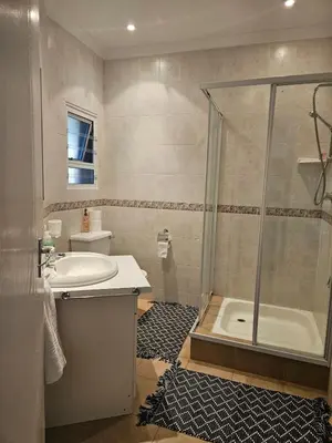 a bathroom with a shower and a sink and a tub at Fair View 2 in Somerset West