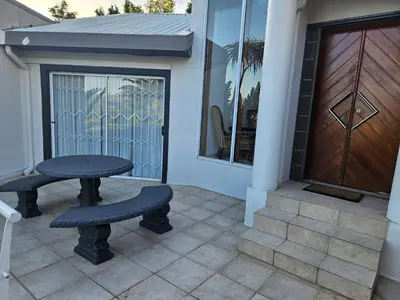 a table and a bench sitting on a patio at Fair View 2 in Somerset West