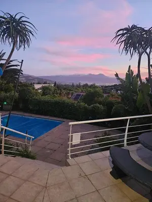 a villa with a swimming pool and palm trees at Fair View 2 in Somerset West