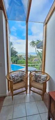 a balcony with two chairs and a view of a pool at Fair View 2 in Somerset West