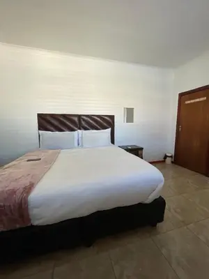 a bedroom with a large bed with white sheets and pillows at Lookout 12 Duminy Guesthouse in Avondale