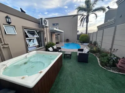 a large jacuzzi tub in a yard with a patio at AquaPalms Hideaway - Family Friendly Pool & Hot Tub in Cape Town