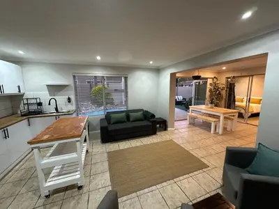 a living room with a couch and a table at AquaPalms Hideaway - Family Friendly Pool & Hot Tub in Cape Town