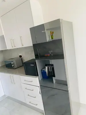 a kitchen with white cabinets and a microwave at Plattekloof Queens Guest House in Welgelegen