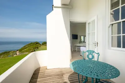 a blue chair sitting on a balcony with a view of the ocean at The Marine Hermanus in Hermanus