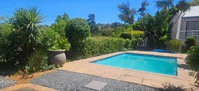 a swimming pool in front of a house at Fair View in Somerset West