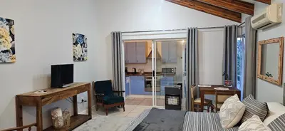 a living room with a desk and a room with a kitchen at Fair View in Somerset West