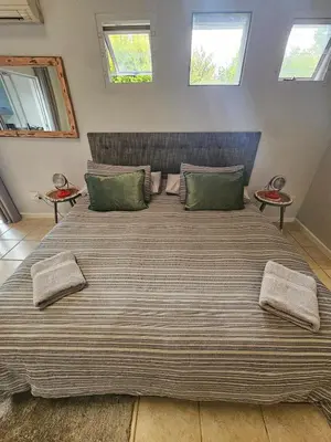 a large bed with green pillows in a bedroom at Fair View in Somerset West