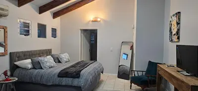 a bedroom with a bed and a desk and a television at Fair View in Somerset West