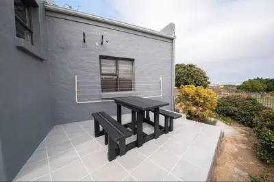 a picnic table and two benches on a patio at Units on 8Wingerd in Somerset West