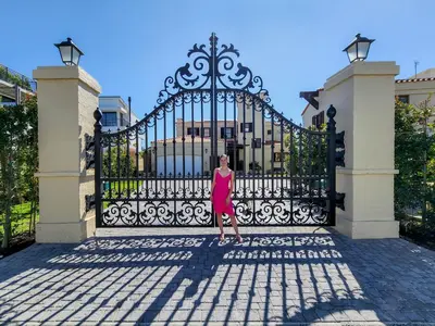 a woman standing in front of a gate at Luxury beachfront villa Cape Town - Sunset Beach in Cape Town