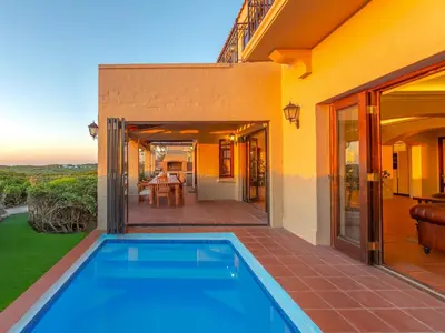 a house with a swimming pool on a patio at Luxury beachfront villa Cape Town - Sunset Beach in Cape Town