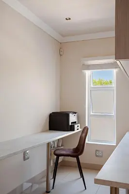 a kitchen with a desk with a microwave and a chair at Cassamo house in Cape Town