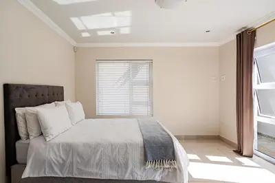 a bedroom with a bed and a window at Cassamo house in Cape Town