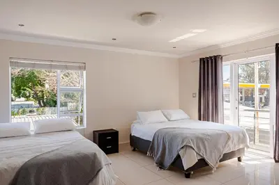 a bedroom with two beds and a window at Cassamo house in Cape Town
