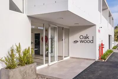 a white building with the oak wood sign on it at The Wild Oak in Hermanus