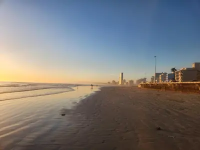a person walking on the beach at sunset at Strand Beach House in Strand
