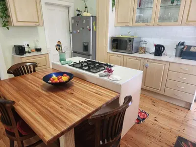 a kitchen with a table with a bowl of fruit on it at Strand Beach House in Strand