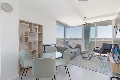 a living room with a table and chairs at Stylish 2-Bedroom Sea-View Apartment Horizon Bay Blouberg Beachfront in Cape Town