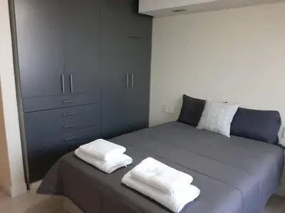 a bedroom with a bed with two white towels on it at Cottage on Abelia in Helderberg